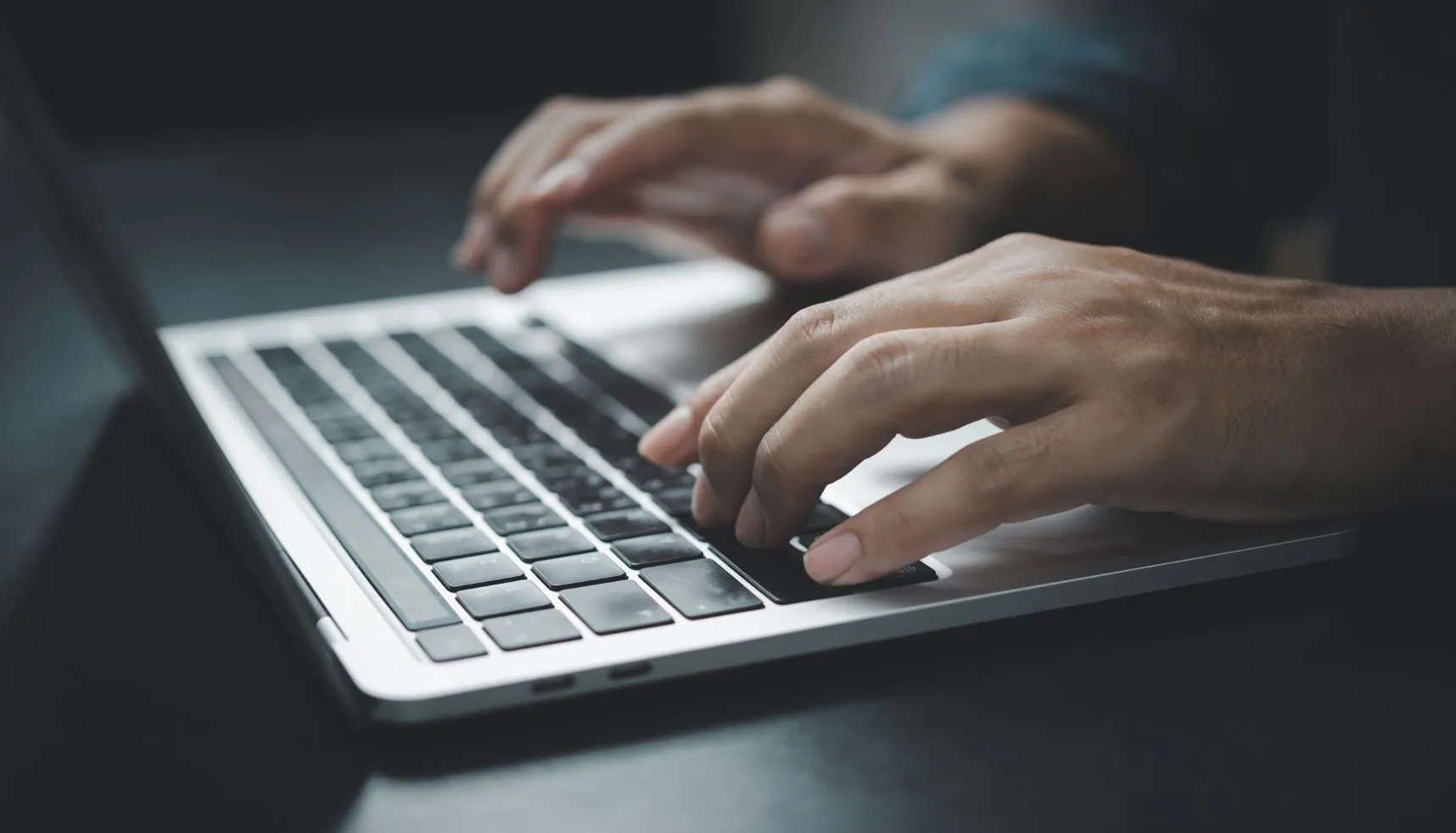 mano escribiendo en un teclado de computadora
